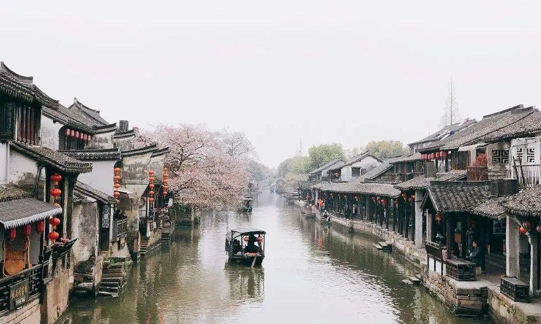 图为施工人员细心描绘滨河步道旁的文化墙。